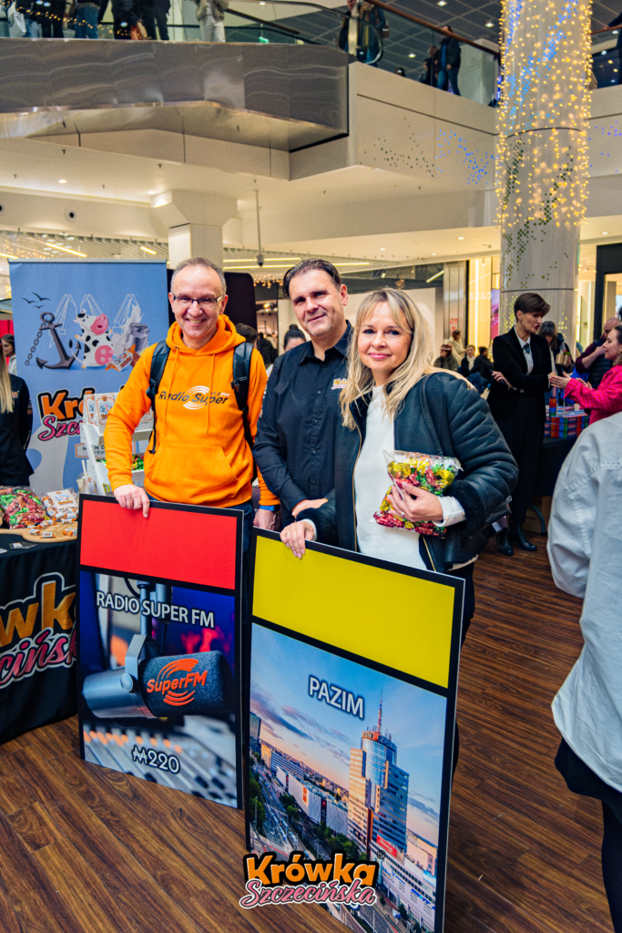 Prezes Krówki Szczecińskiej Janusz Germanek w towarzystwie P. Mirelli Iwaniury (Pazim) oraz P. Jarosława Fenglera (Super FM) wraz z kartami z gry Monopoly Szczecin